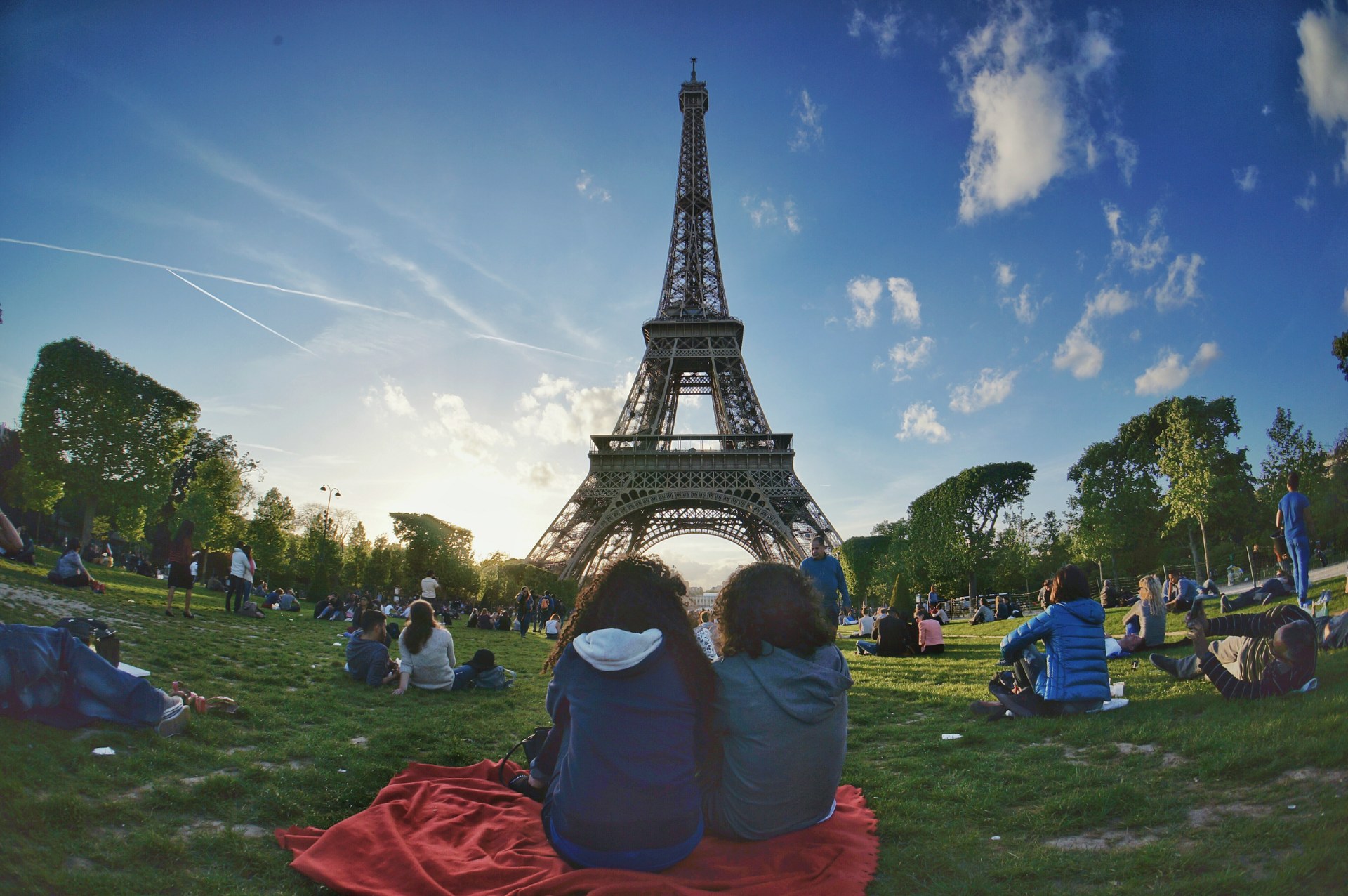 Des jeunes se détendent sur la pelouse du Champ-de-Mars, avec la tour Eiffel en arrière-plan